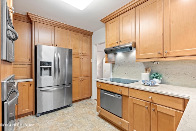 kitchen featuring appliances with stainless steel finishes, light stone counters, and decorative backsplash