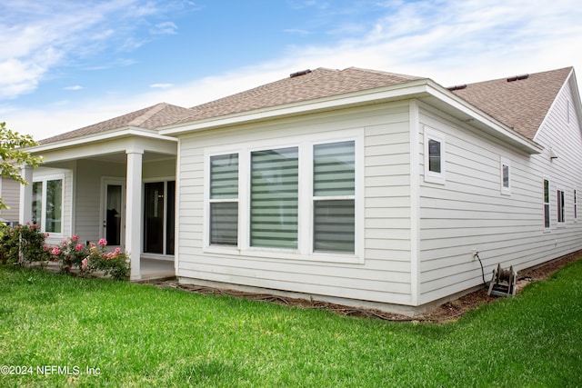 rear view of property featuring a lawn