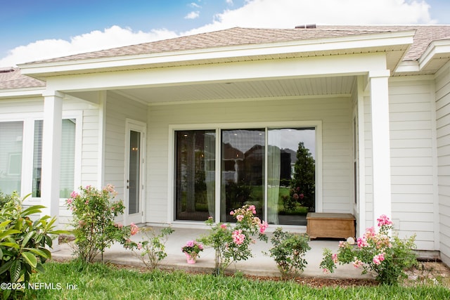 view of exterior entry featuring covered porch