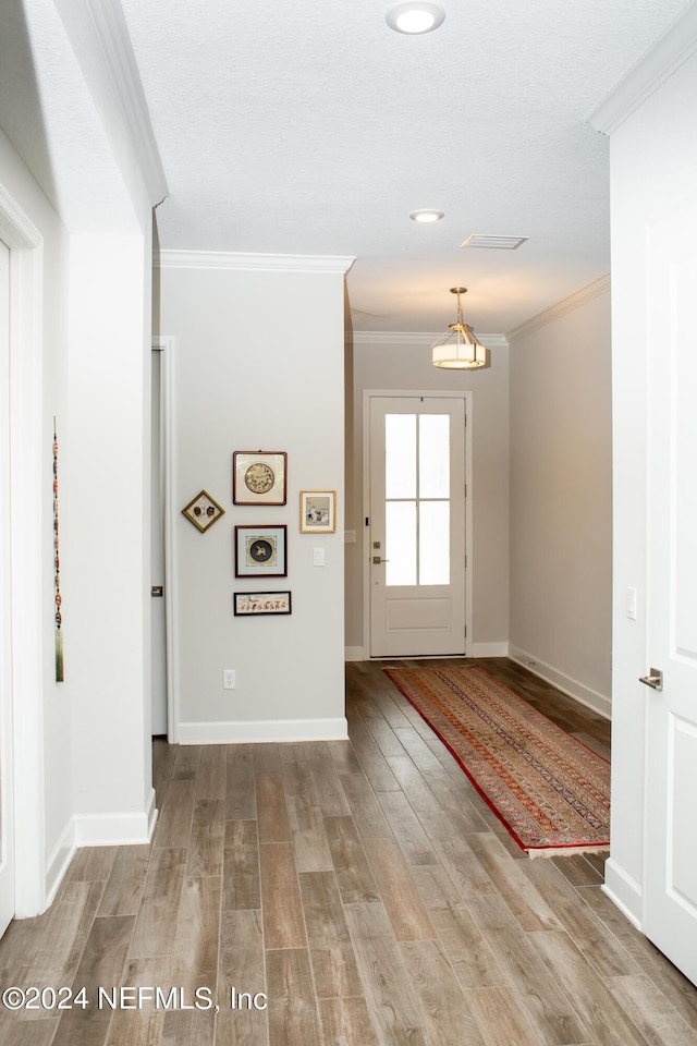 entrance foyer with light hardwood / wood-style floors and ornamental molding