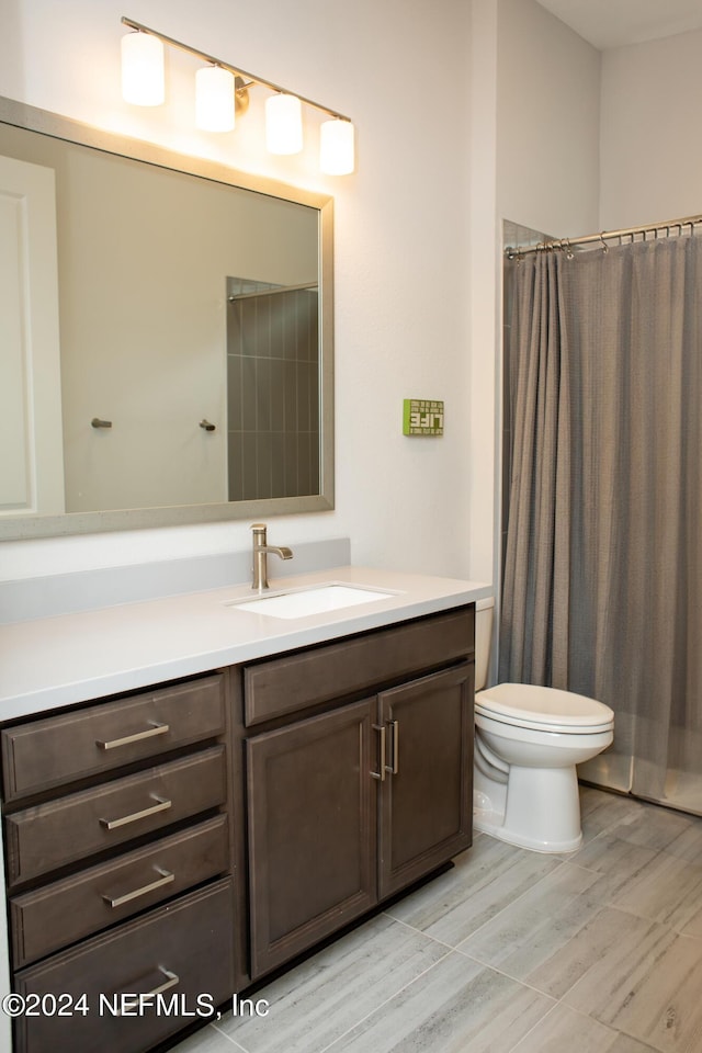 bathroom featuring vanity, toilet, and curtained shower