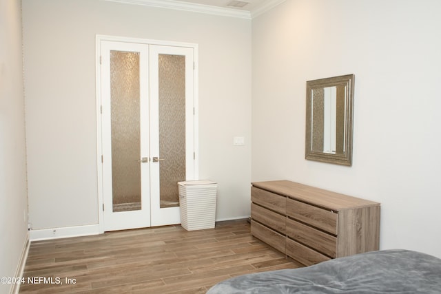 bedroom featuring crown molding, a closet, french doors, and hardwood / wood-style flooring