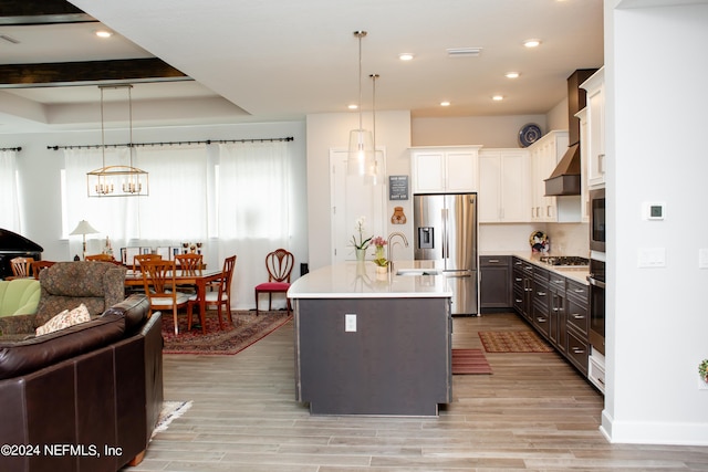 kitchen with pendant lighting, white cabinetry, an island with sink, and appliances with stainless steel finishes