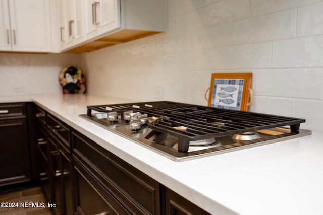 kitchen with dark brown cabinetry, white cabinets, and stainless steel gas stovetop