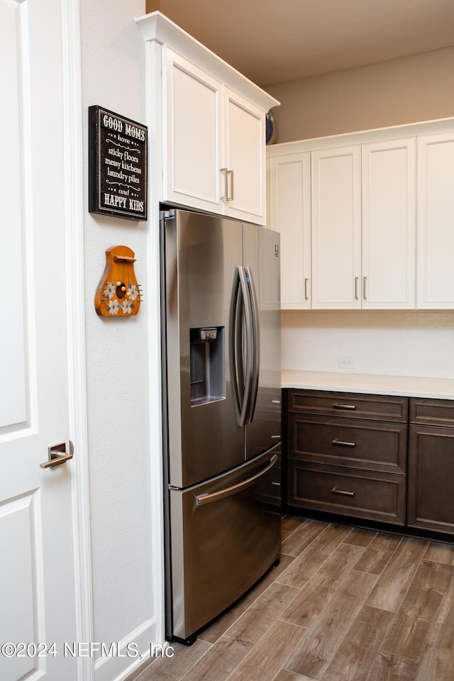 kitchen featuring stainless steel fridge with ice dispenser, dark brown cabinets, and white cabinets