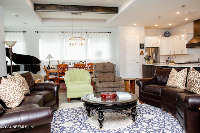 living room with a chandelier, beam ceiling, and a healthy amount of sunlight