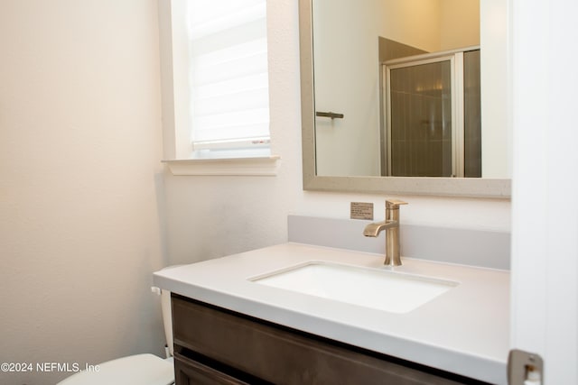 bathroom with vanity, toilet, and walk in shower