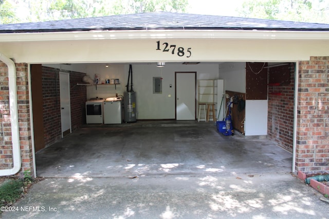 garage featuring electric panel, water heater, washer and dryer, and concrete driveway