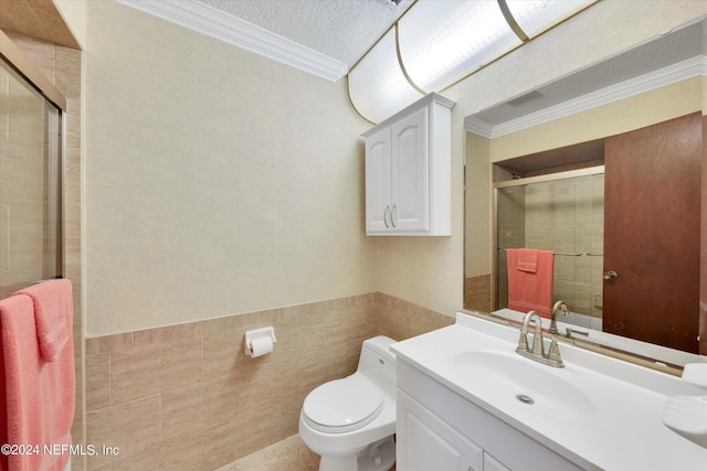 bathroom with toilet, a shower stall, tile walls, and vanity