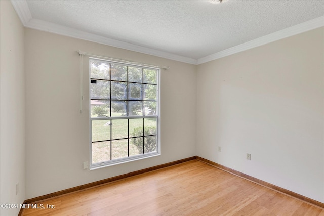 empty room featuring light wood-style flooring, crown molding, baseboards, and a textured ceiling