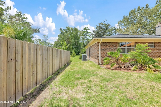 view of yard with fence and central air condition unit