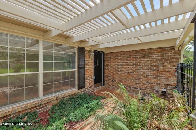 property entrance featuring brick siding and a pergola