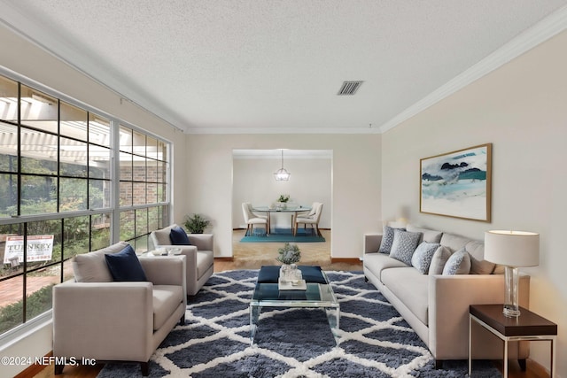 carpeted living room featuring a textured ceiling, visible vents, a wealth of natural light, and ornamental molding