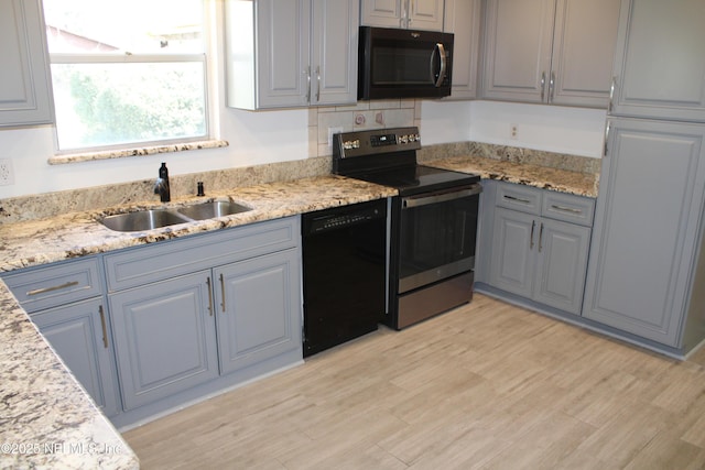 kitchen with black dishwasher, light wood finished floors, a sink, and stainless steel range with electric cooktop