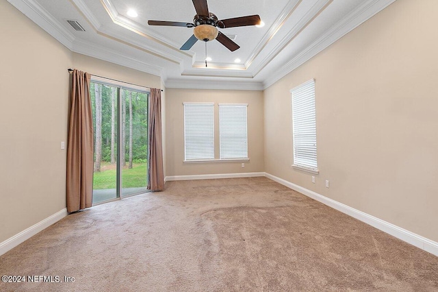 carpeted spare room featuring a tray ceiling, ceiling fan, and ornamental molding