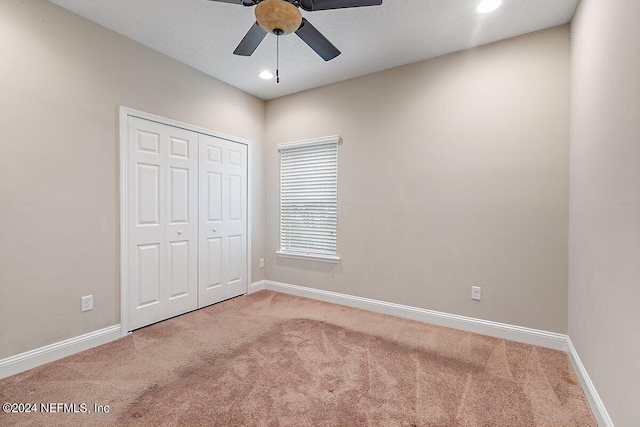 unfurnished bedroom with carpet flooring, ceiling fan, and a closet