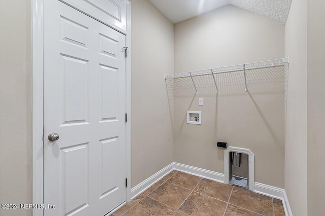 laundry room featuring washer hookup and a textured ceiling