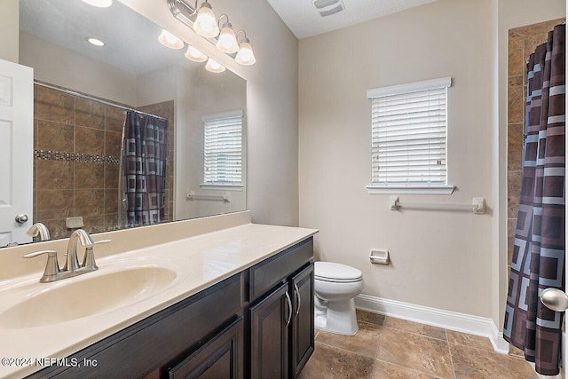 bathroom featuring vanity, toilet, and walk in shower