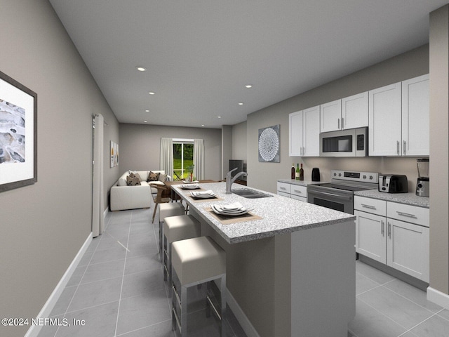 kitchen with appliances with stainless steel finishes, an island with sink, white cabinetry, and sink