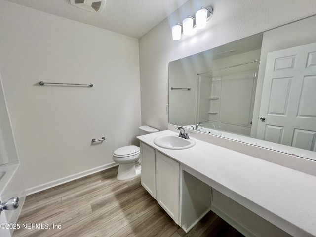 bathroom with toilet, vanity, and hardwood / wood-style flooring