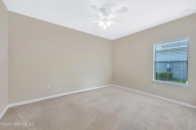 carpeted empty room featuring ceiling fan