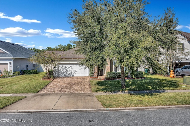 obstructed view of property featuring a garage and a front lawn