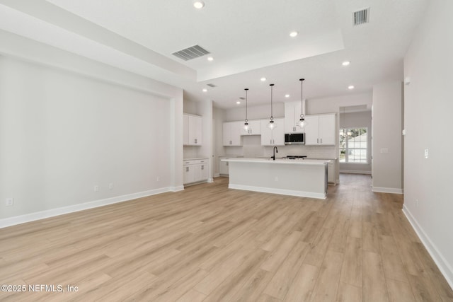 unfurnished living room with light wood-type flooring and sink