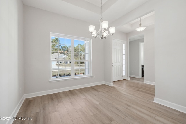 unfurnished dining area with light hardwood / wood-style flooring and an inviting chandelier