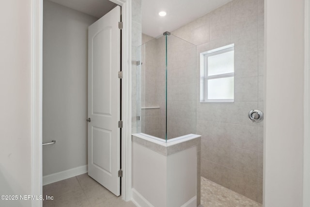 bathroom featuring tile patterned flooring and a tile shower