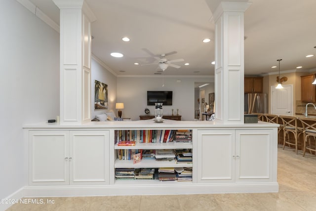 bar with decorative columns, stainless steel refrigerator, and crown molding