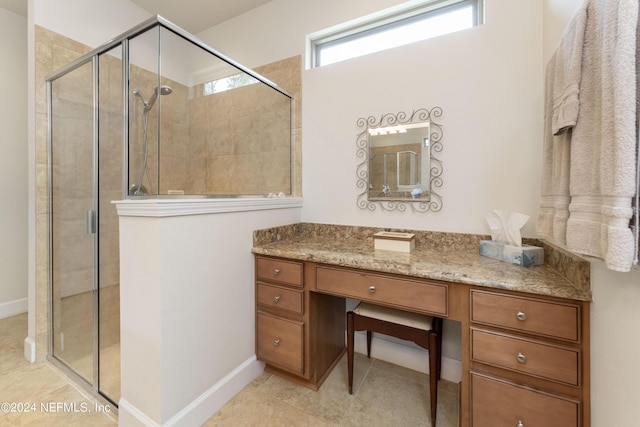 bathroom featuring tile patterned flooring, vanity, and a shower with door