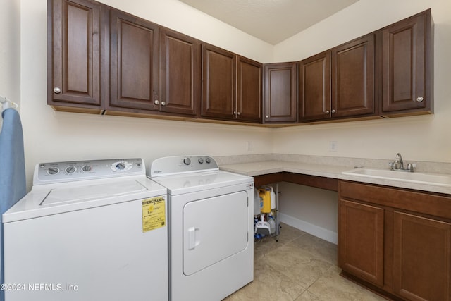 laundry area featuring cabinets, independent washer and dryer, and sink