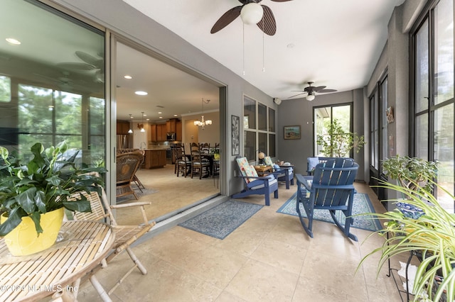 sunroom / solarium with ceiling fan with notable chandelier