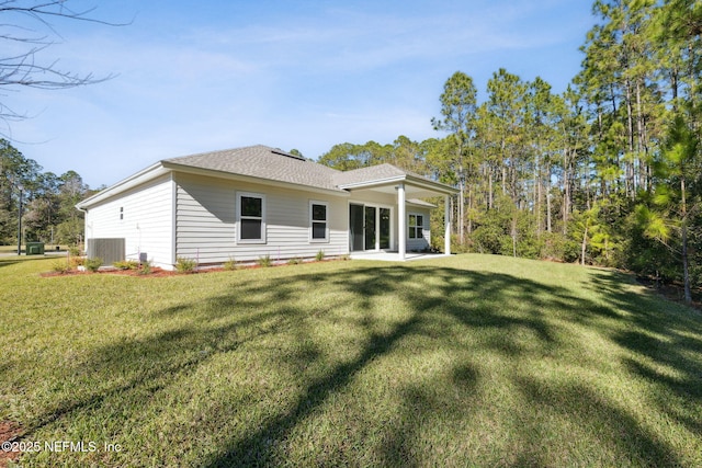 back of house with central AC and a lawn