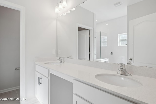 bathroom featuring tile patterned flooring, vanity, and a shower