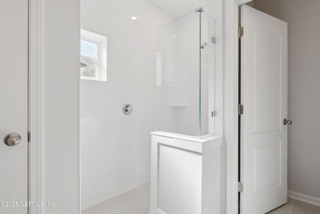 bathroom with tiled shower and tile patterned floors