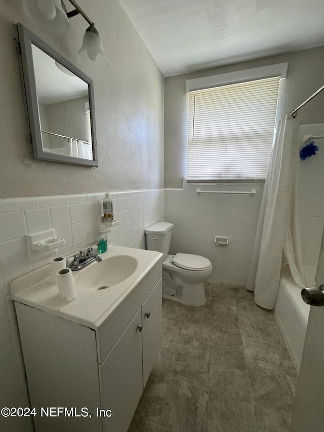 full bathroom with tile walls, vanity, shower / bath combo, and toilet