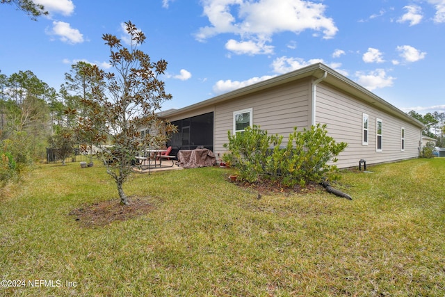 view of property exterior featuring a patio and a lawn