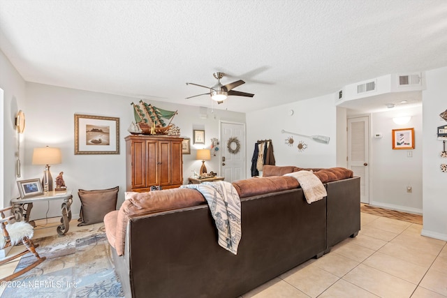 tiled living room featuring a textured ceiling and ceiling fan