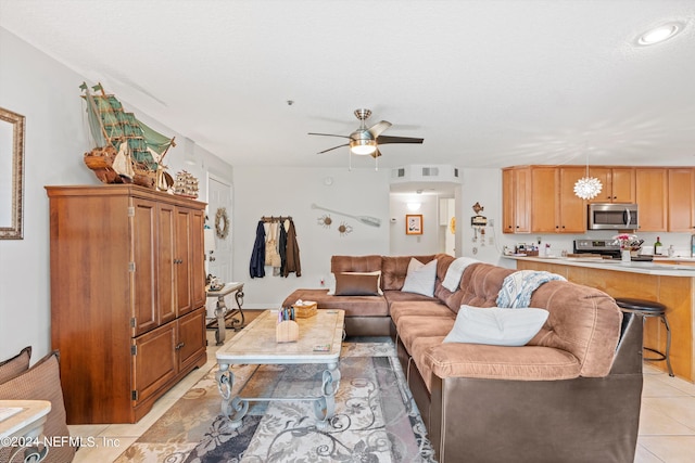 living room with ceiling fan, a textured ceiling, and light tile patterned floors