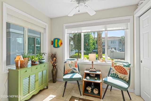 living area with ceiling fan and light tile patterned floors