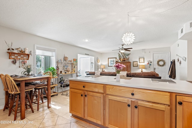 kitchen with a textured ceiling, ceiling fan, and light tile patterned floors