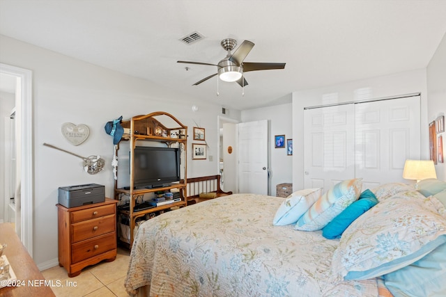 tiled bedroom featuring ceiling fan and a closet