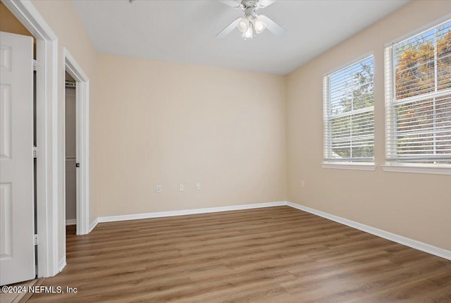 unfurnished bedroom featuring multiple windows, ceiling fan, and hardwood / wood-style floors