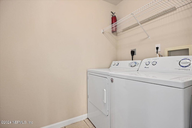 washroom with washer and clothes dryer and light tile patterned floors