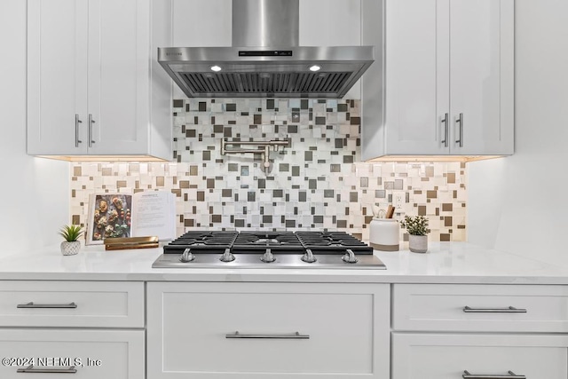 kitchen with stainless steel gas stovetop, white cabinetry, decorative backsplash, and extractor fan