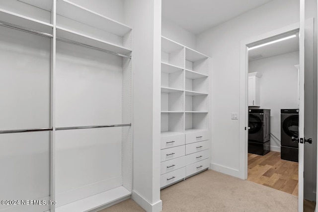 spacious closet featuring light carpet and washer and clothes dryer