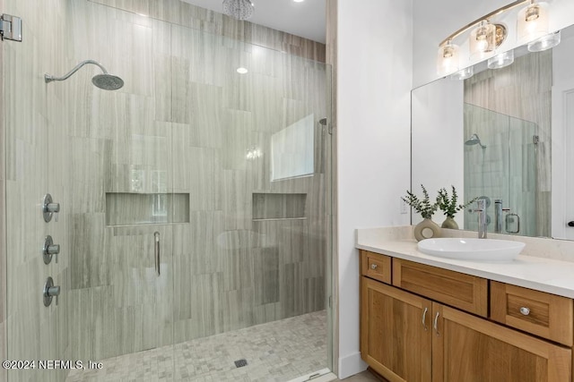 bathroom with a shower with shower door and vanity