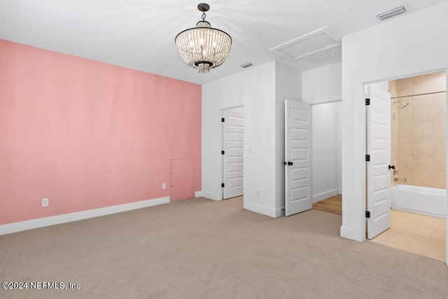 unfurnished bedroom with connected bathroom, a notable chandelier, and light colored carpet