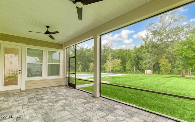 unfurnished sunroom with ceiling fan